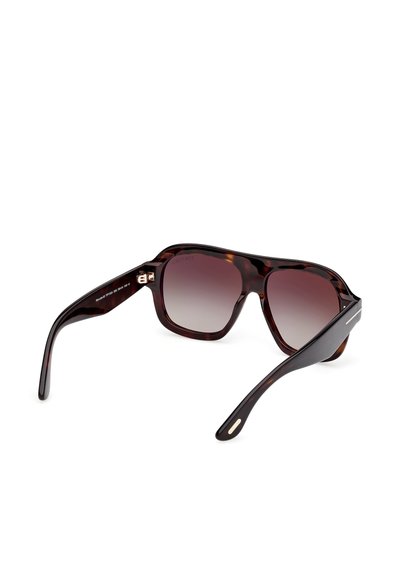 Ochelari de soare dreptunghiulari din material brocade cu lentile întunecate cu degradé și brațe groase, unghiulare pentru a arăta detaliile textului de pe brațul stâng interior și ale îmbinării.