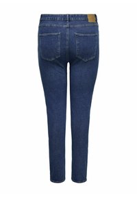 Vaqueros skinny azul en denim elástico con bolsillos traseros y una etiqueta de cuero marrón en la cintura. Acabado limpio sin adornos.