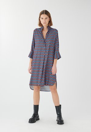 Abito camicia stampato con colletto, maniche a tre quarti svasate e orlo asimmetrico, caratterizzato da un design geometrico nei toni del blu e del rosa.