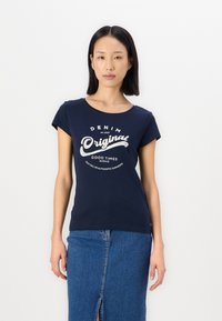 Navy blå bomull T-skjorte med korte ermer, rund hals og grafisk trykk som viser "DENIM Original" i hvitt og sølv.