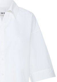 Chemise blanche à manches courtes avec col classique, boutonnée, affichée sur un cintre sur fond blanc.