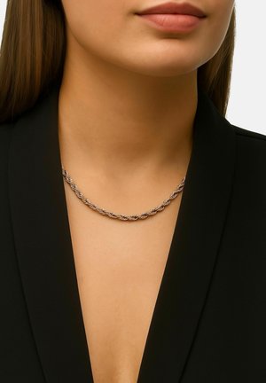 Silberne, gedrehte Kettenhalskette, die am Hals ruht, mit einer glatten Textur und einem filigranen Design, getragen über einem schwarzen Kleidungsstück.