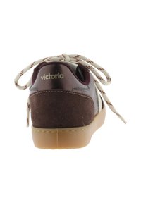 Zapatilla de cuero marrón y ante con acentos blancos, forma redondeada, suela de goma color tostado y cordones crema con un patrón marrón. Logo en el talón.