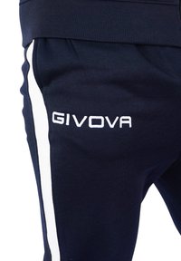 Mornarsko modri trenirki s belimi stranskimi črtami, izdelani iz teksturirane tkanine, s logotipom "GIVOVA" v belem vezenju na levem stegnu.