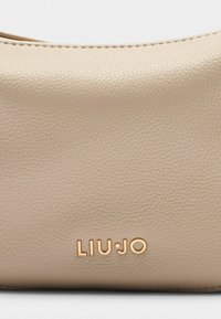Borsa in pelle beige e textured con una finitura liscia. Presenta un logo in tonalità oro "LIU JO" stampato sul davanti. Design semplice e curvato.