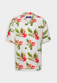 Camisa de manga corta en tejido ligero con un fondo blanco y un patrón de duraznos y hojas. Con botones en la parte delantera, de corte holgado.