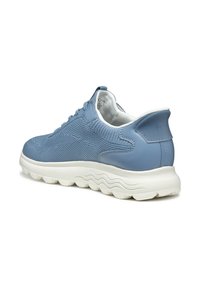 Baskets de sport bleu clair avec tige en mesh respirant, col rembourré et semelle épaisse blanche au design ondulé.