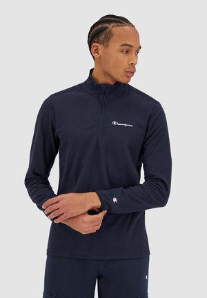 Felpa zip-up blu navy realizzata in materiale morbido, con colletto alto e logo del marchio ricamato sul petto e sulla manica.