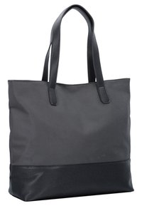 Sac fourre-tout noir avec base texturée et longues anses, fabriqué en tissu lisse et matériau semblable au cuir, posé debout sur un fond blanc.