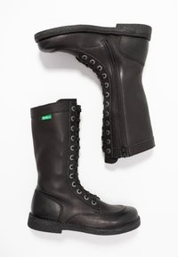 Black leather military-style boots with a smooth finish, lace-up front, and a side zipper. Rubber sole with a textured edge.