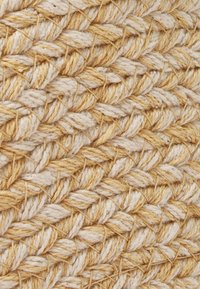 Tessuto intrecciato con un motivo testurizzato, caratterizzato da fili beige e marrone chiaro in un design a incrocio, che mostra fibre naturali.