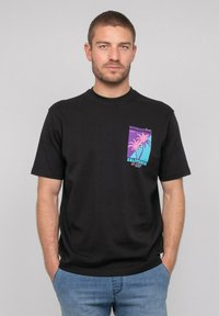 T-shirt noir à manches courtes avec un motif coloré de palmiers sur une poche et le texte "CALIFORNIA". Fabriqué en coton, coupe régulière.
