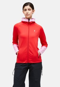 Red zip-up jacket with pink accents on the cuffs and collar. Features a logo on the chest and side pockets. Made of lightweight fabric.