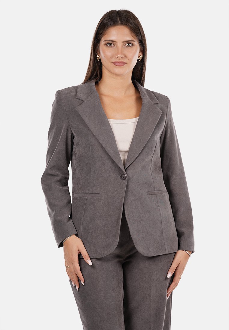Blazer grigio in suede con chiusura a singolo bottone, rever a pistagna e due tasche frontali, completato da una silhouette aderente.