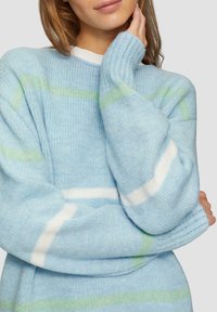Jasnoniebieski sweter w zielone i białe paski, wykonany z miękkiej, teksturowanej tkaniny; ma luźny krój i długie rękawy.
