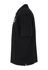 Svart kortärmad pikéskjorta i bomull. Har en ribbad krage, sidoflikar och en liten logotyp på bröstet och ärmen. En enkel, klassisk design.