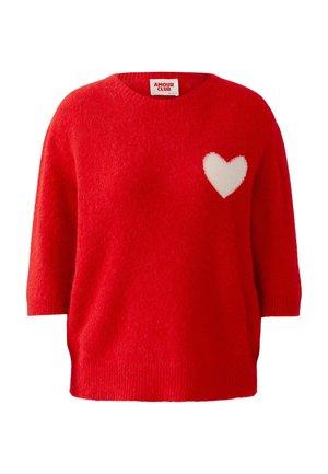 Roter Strickpullover mit lockerem Sitz, kurzen Ärmeln und einem weißen Herzmotiv auf der linken Brust. Strukturierter Stoff mit geripptem Saum.