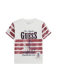 T-shirt bianca in cotone con maniche a righe rosse e bianche. Presenta una grafica di una barca a vela, "Los Angeles Guess," e il testo "Established 1981."