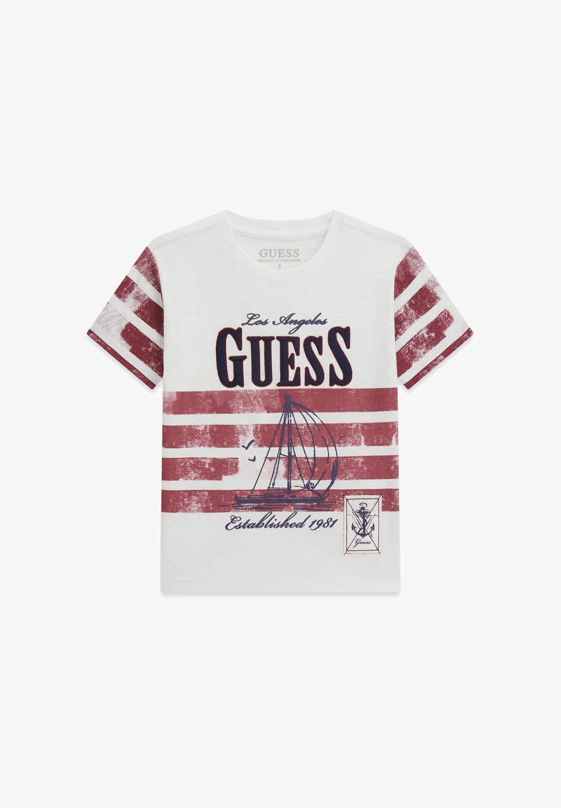 T-shirt bianca in cotone con maniche a righe rosse e bianche. Presenta una grafica di una barca a vela, "Los Angeles Guess," e il testo "Established 1981."