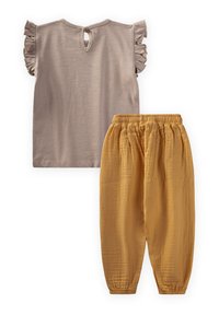 Beige, gerafft, kurzärmeliges Oberteil mit einem Schlüsselloch im Rücken und lockeren, senfgelben Hosen mit elastischem Bund und gerafften Bündchen.