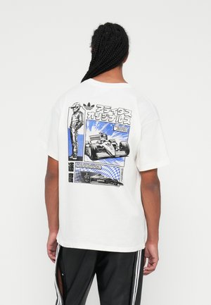 Biała koszulka graficzna z motywem wyścigów samochodowych w niebiesko-czarnym kolorze z napisem. Luźny krój, krótkie rękawy i dekolt typu crew neck.