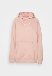 Ljusrosa hoodie i mjukt material, med en framfickan i kängurustil som har dragkedja, dragskodder och en vit Nike-logga på bröstet.