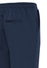 Pantalon bleu marine avec ceinture élastique, poche latérale et une seule poche arrière, présenté de la taille au milieu de la cuisse.