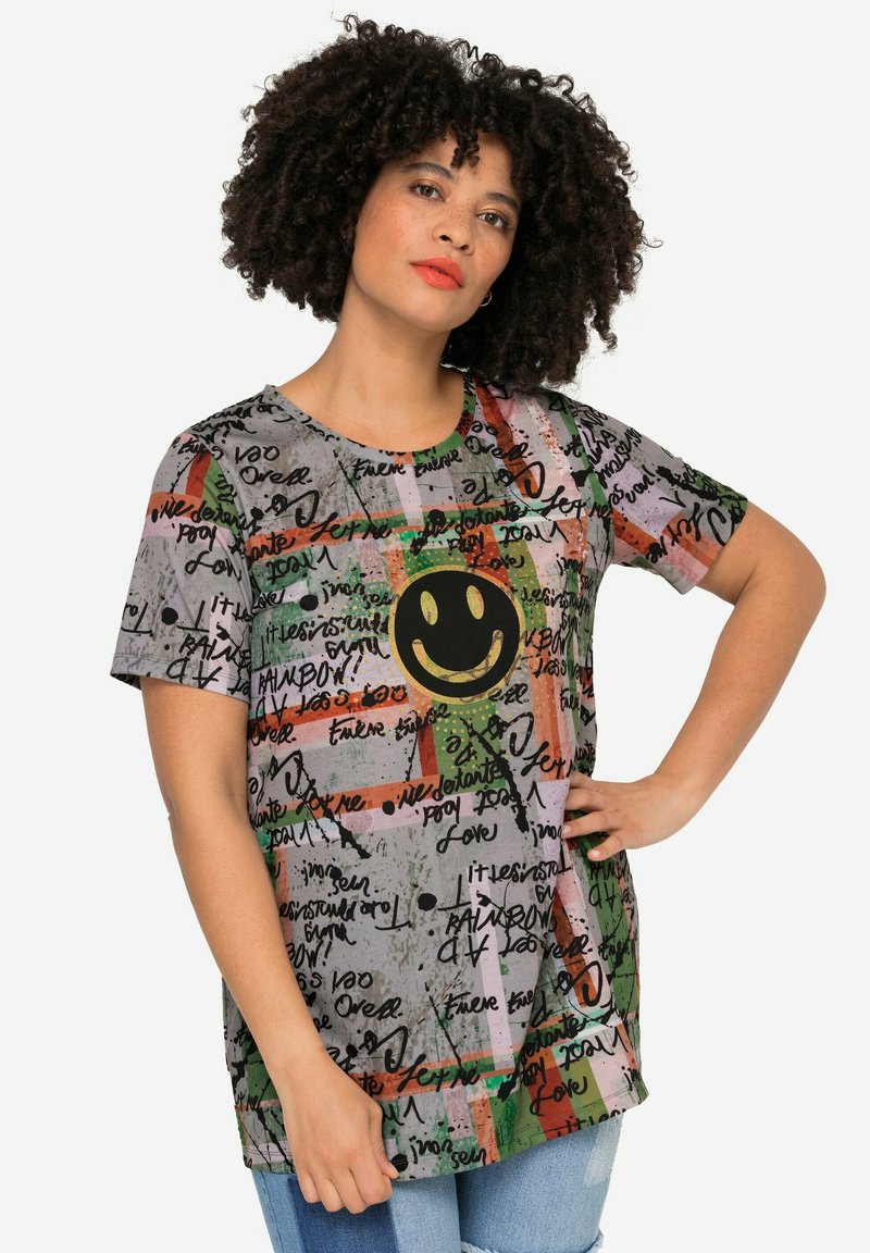 Grijs T-shirt met korte mouwen, voorzien van een smiley gezichtsontwerp, kleurrijke patronen en handgeschreven tekst in verschillende kleuren. Zachte stof.