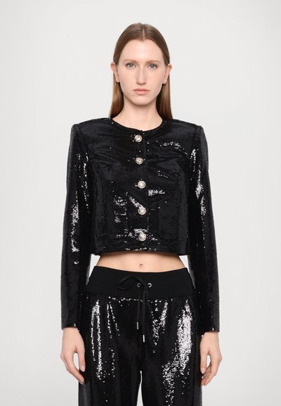 Black cropped sequin jacket with long sleeves, round neckline, five silver buttons, and two front pockets. Paired with black sequin pants.