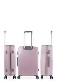 Maleta rígida en rosa claro con cremallera y asa plateadas. Cuenta con cuatro ruedas y un asa retráctil. Acabado suave y brillante.