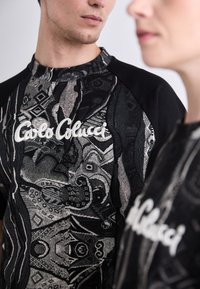 Sweatshirts i sort og hvid med mønster har et design med komplekse grafikker og broderet logo, rund hals og raglanærmer.