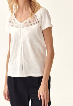 Weißes kurzärmeliges T-Shirt mit V-Ausschnitt, das auf der Brust über feine Spitze verfügt und eine lockere Passform hat. Glatte Textur.