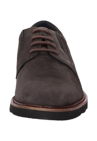 Chaussures en daim marron à lacets avec un bout arrondi, des lacets marron contrastés et une semelle en caoutchouc noir. Présente une couture et des accents minimaux.