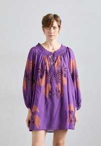 Robe violette à manches longues, ornée d'un motif floral orange brodé, encolure smockée avec un lien, et coupe ample. Tissu doux et léger.