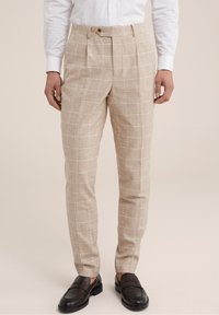 Béžové kostkované kalhoty vyrobené z lnu, s upraveným střihem, klasickými sklady a hladkou texturou. Dokončeny zapínáním na knoflík.