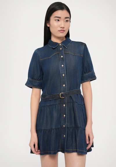 Džínové šaty s krátkymi rukávmi, golierom a zapínaním na gombíky. Tmavomodré, viacvrstvové prevedenie so zúženým pásom, doplnené o opasok rovnakej farby a zlaté detaily.