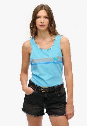 Top in cotone blu senza maniche con scollatura arrotondata e righe orizzontali; grafica di una palma; abbinato a pantaloni corti in denim neri e una cintura nera.