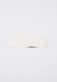 Valge kinga talla tekstuuriga kummipind ja sooned. Veidi ümar varbaosa. Siledad servad ja minimalistik disain.