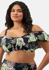 Musta bikinitoppi, jossa on vihreä ja vaaleanpunainen trooppinen lehtikuosi, röyhelöyksityiskohtia ja avonaiset hihat. Pehmeää kangasta, jossa on säädettävät hihnat.