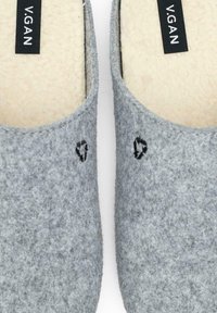 Gray felt slippers with a soft, cream inner lining. Features small black heart embroidery and a black label with "V.GAN" text.