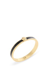 Bracelet jonc doré avec une bande d'émail noir lisse et un fermoir circulaire avec une marque gravée. Design épuré et minimaliste.