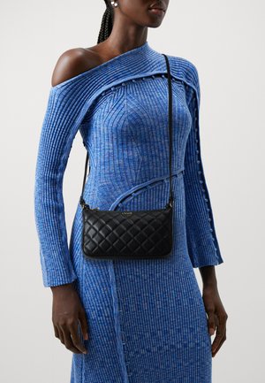 Bolso de crossbody negro acolchado con forma plana, fabricado en material sintético suave, complementado con una correa larga y detalles de hardware dorado.