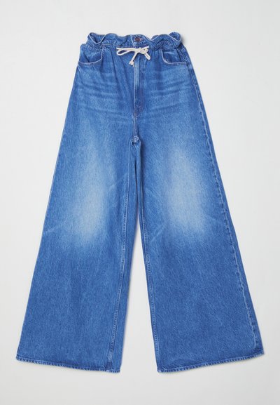 Φαρδύ τζιν παντελόνι από μπλε denim με ελαστική μέση και κορδόνι. Διαθέτει δύο μπροστινές τσέπες και λεπτομέρεια ξεθωριασμένου αποτελέσματος.