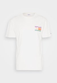Camiseta de algodón blanca con un parche en el pecho que presenta el colorido logo de "Tommy Jeans" en púrpura, verde y rojo. Mangas cortas y escote redondo.