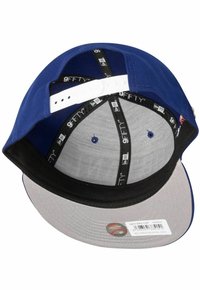 Blaues Cap mit einem flachen grauen Schirm. Das Innere ist mit einem Mesh-Futter versehen und hat einen verstellbaren weißen Kunststoffriemen. Das "9FIFTY"-Label ist sichtbar im Inneren.