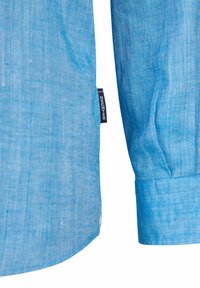 Lichtblauwe lange mouwen shirt met een gestructureerde stof. Heeft een afgeronde zoom, een knoopmanchet en een klein merkembleem aan de zijsam.