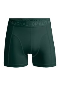 Tumši zaļi bokseri ar gludu tekstūru, kam ir plašs jostasvīrs ar iegrieztu zīmolu "MUCHACHOMALO." Sīkas šuvju detaļas redzamas.