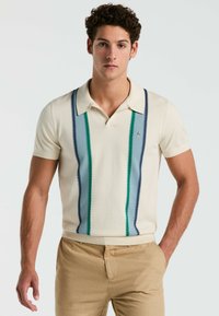 Crème poloshirt met korte mouwen en verticale strepen in blauw, groen en marineblauw. Inclusief een kraag en een decoratief logo.