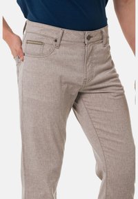 Helle graue Hose mit strukturiertem Muster, vorderer Tasche mit Akzent und taillierter Passform. Aus strapazierfähigem Stoff mit Reißverschluss.