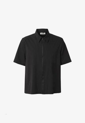 Sort kortærmet skjorte med krave og lynlås foran, vist mod en hvid baggrund.